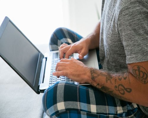 Person typing on laptop with a relaxed posture